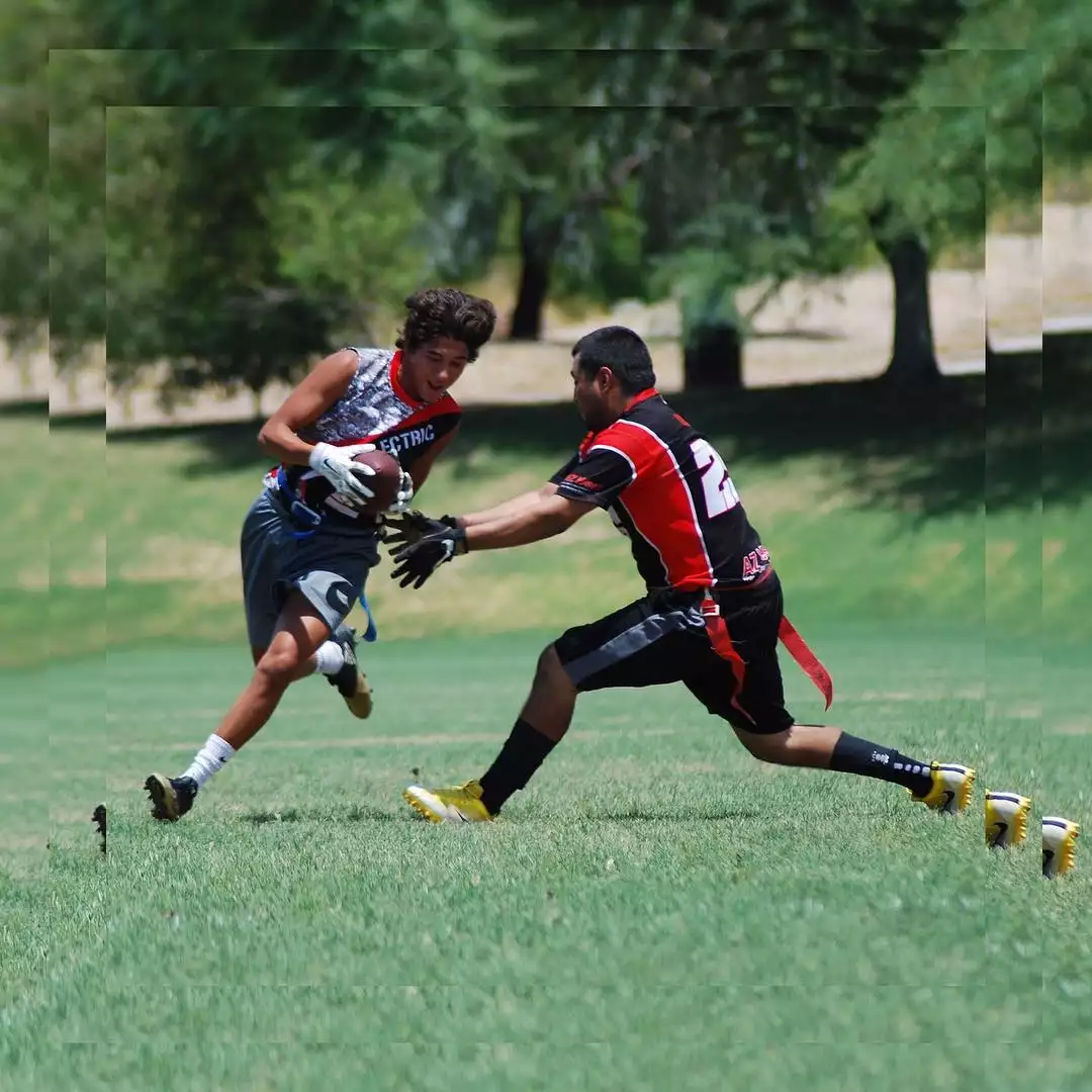 Flag football players playing on field playing flag football wearing custom flag football uniforms.