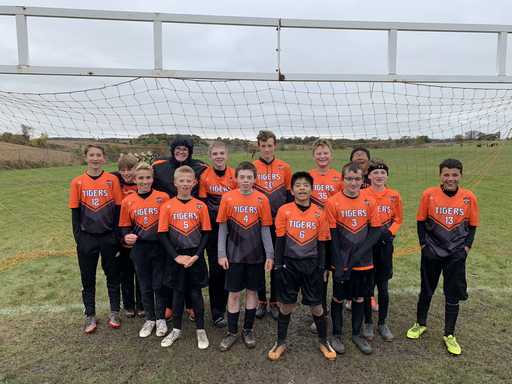 Team wearing orange custom raglan sleeve soccer jerseys outdoors