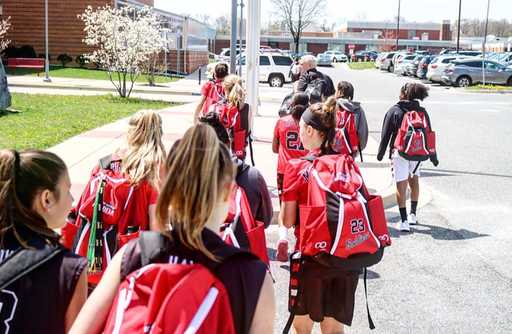 Basketball team carrying red custom basketball bags outdoors