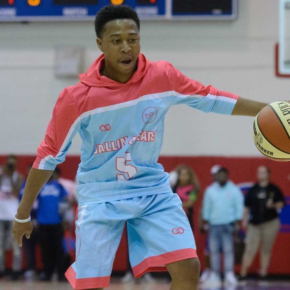 Player wearing light blue basketball shooting shirt with hood outdoors