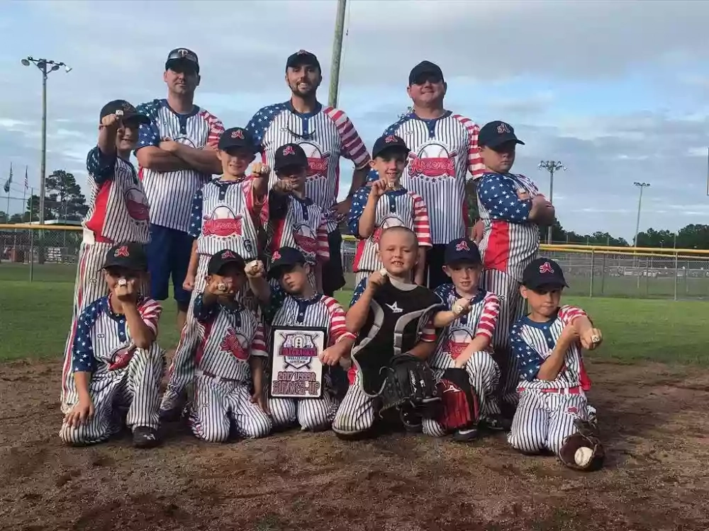 Youth team wearing gray 2 button baseball jerseys on field