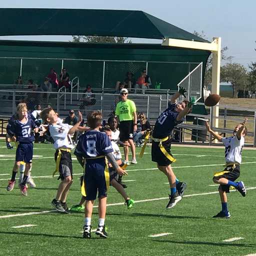 Youth flag football players wearing custom shorts on field