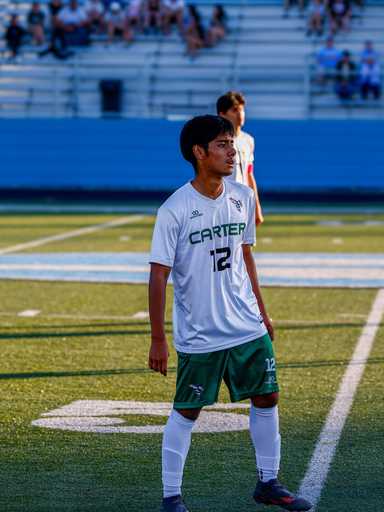Player wearing white custom reversible v-neck soccer jersey on field