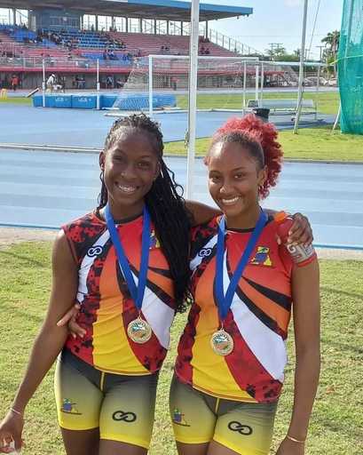 Two athletes wearing custom athletic shorts with medals after event