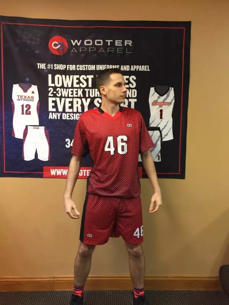 Player wearing red custom v-neck soccer jersey holding soccer ball
