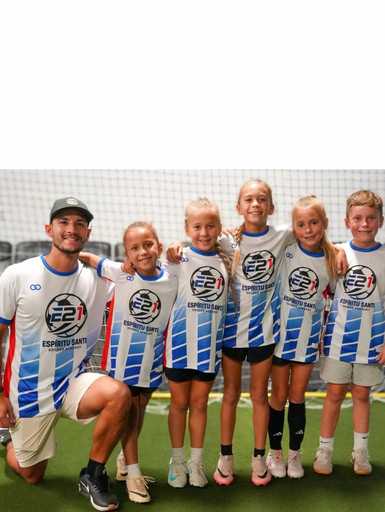 Girls soccer team wearing custom soccer shorts and striped team uniforms on the field