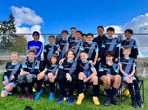 Soccer team in custom black uniforms and custom soccer shorts posing after a match
