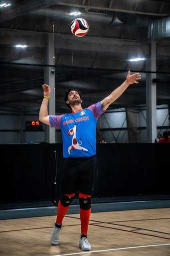 Player wearing reversible short sleeve volleyball jersey on indoor court