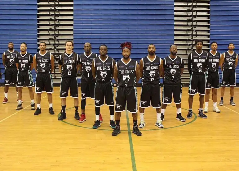 The Grizz Basketball Team on a basketball court wearing black and white custom basketball uniforms.