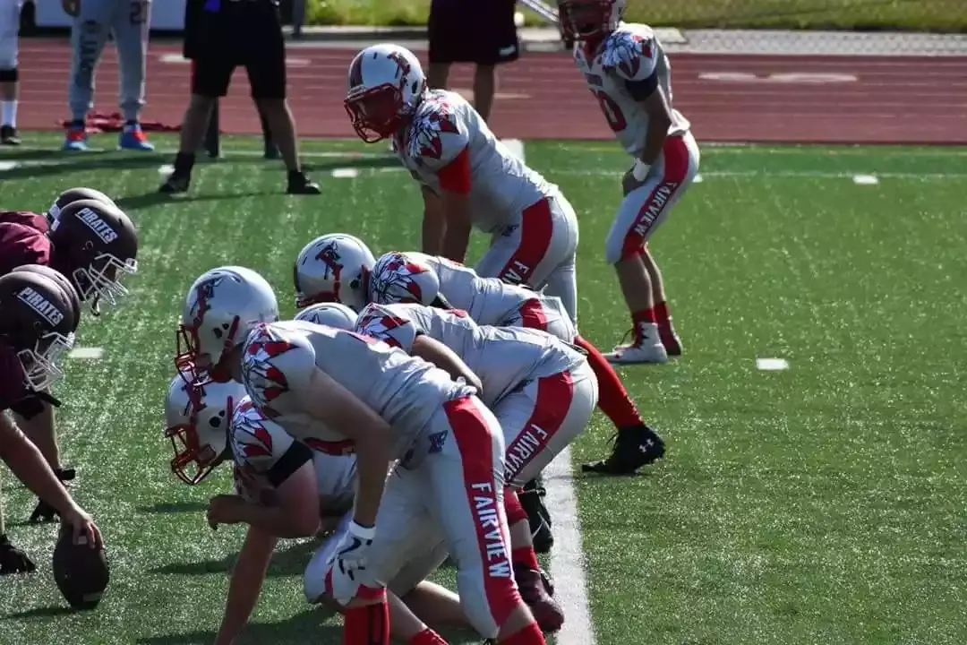 Football players in the line of scrimmage wearing custom football uniforms manufactured by Wooter.