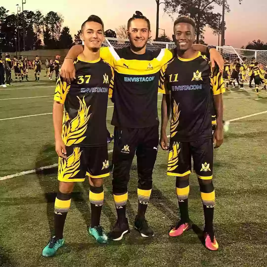 Soccer players wearing black and yellow custom crew neck soccer jerseys